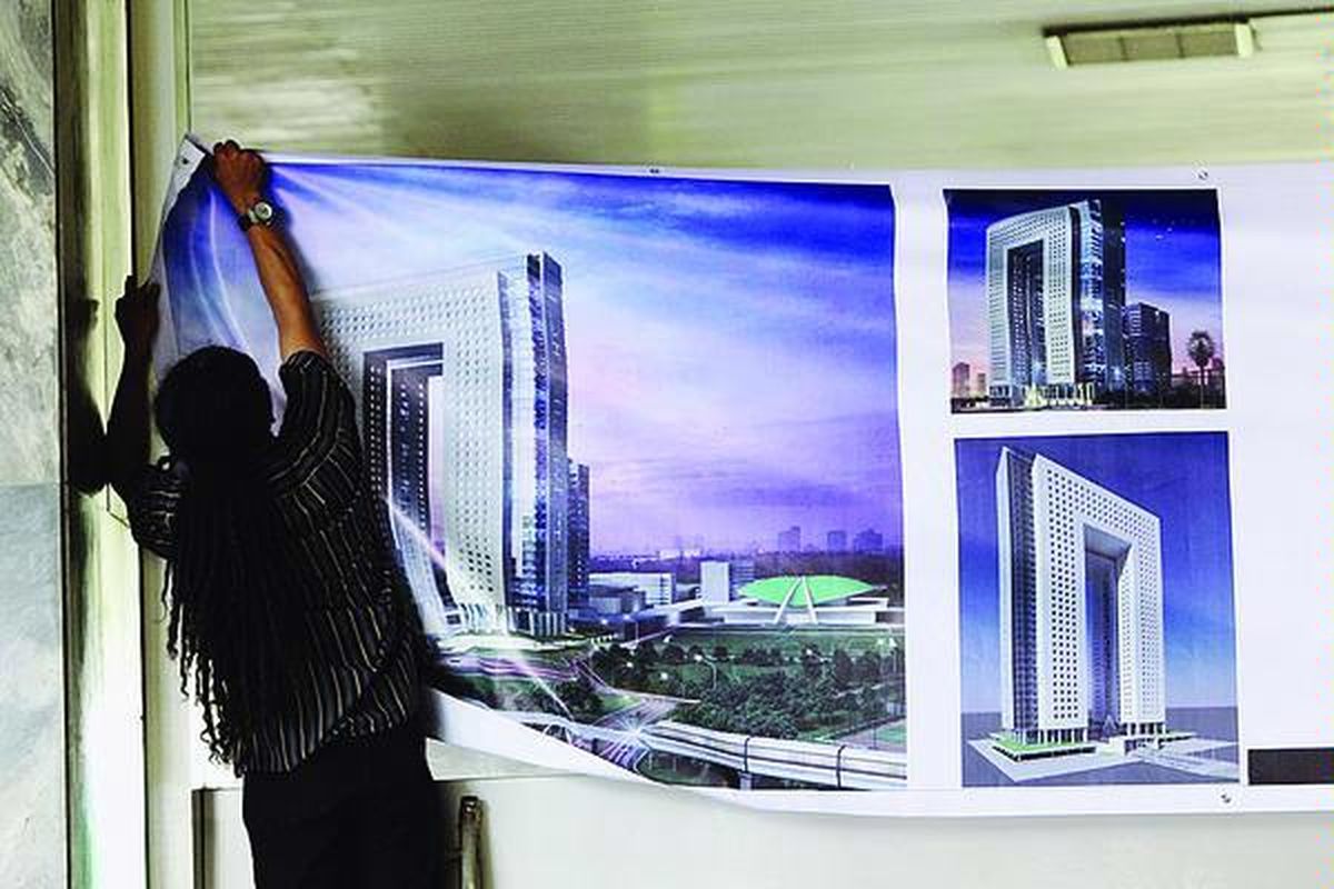 Pekerja memasang poster bergambar desain gedung baru DPR sebelum berlangsung acara sosialisasi pembangunan gedung baru itu oleh Ketua DPR Marzuki Alie dan Badan Urusan Rumah Tangga DPR, Senin (30/8).