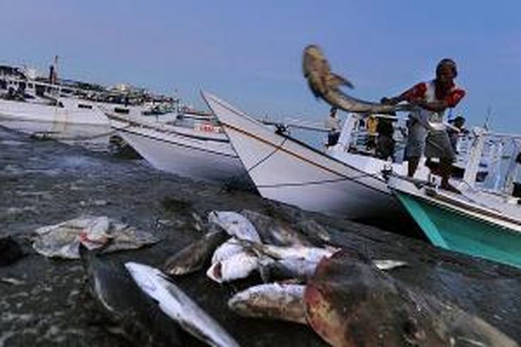 Nelayan menurunkan ikan hasil tangkapan untuk dijual di Pasar Ikan Paotere di Makassar, Sulawesi Selatan.
