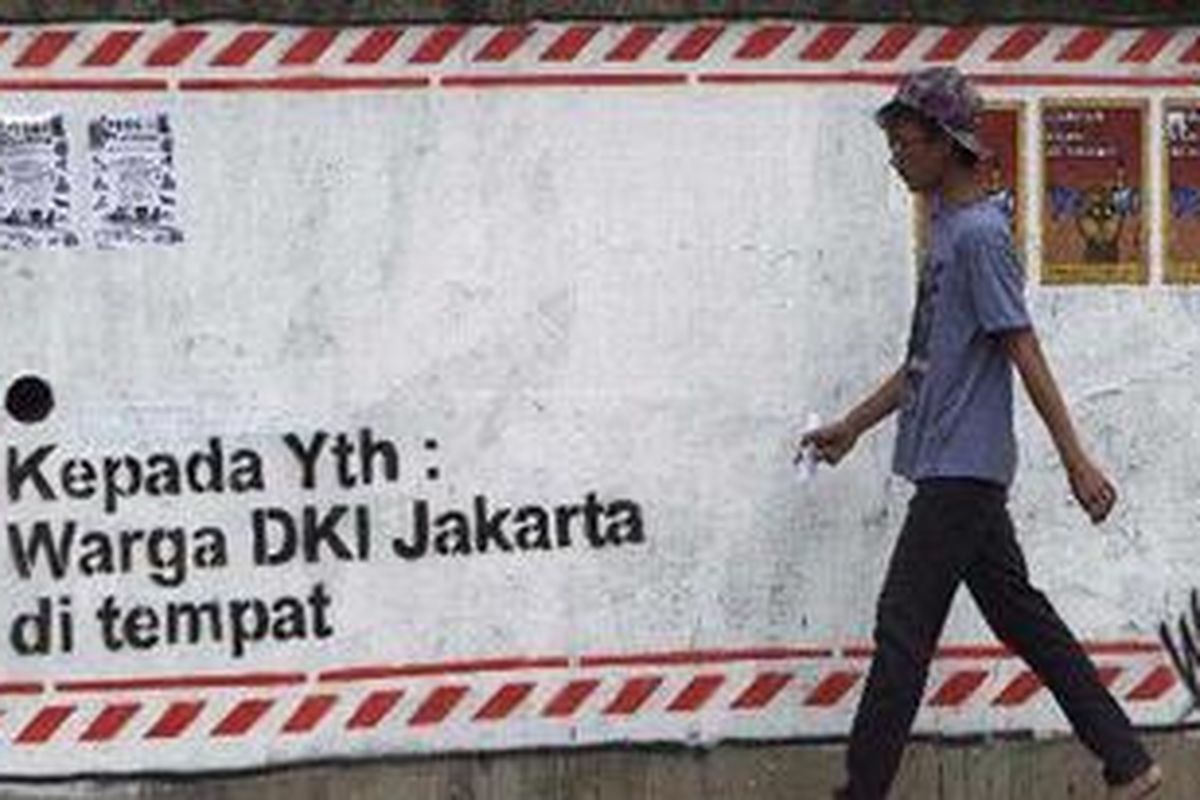 Warga melintas di depan mural amplop dan pamflet perangko bertuliskan Jangan Jual Suaramu dipasang Street Art Peduli Pilkada Jakarta di Jalan Salemba, Jakarta Pusat, Selasa (3/7/2012). Ajakan tersebut mengharapkan pemilih tidak terpana oleh janji-janji calon pemimpin selama kampanye.  