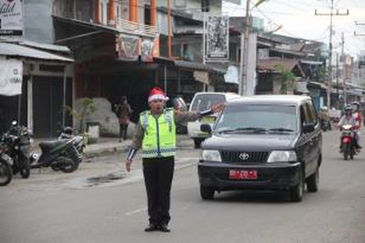 Menyambut kemeriahan Natal, seluruh polisi yang berjaga dan mengatur lalu lintas di Kota Gunungsitoli, Sumatera Utara, mengenakan atribut Natal berupa topi sinterklas.