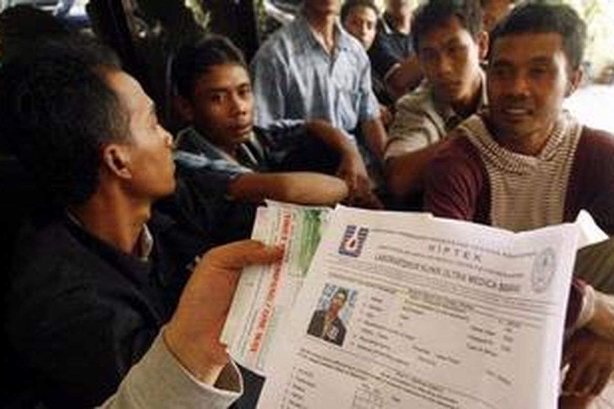 Para tenaga kerja Indonesia (TKI) yang ditangkap aparat dari Polresta Tanjungpinang serta KPPP, saat akan berangkat ke Malaysia di Pelabuhan Internasional Sri Bintan Pura, Tanjungpinang, Senin (27/10). Polisi menemukan para TKI tersebut tidak memiliki dokumen resmi dan hanya menggunakan paspor wisata untuk bekerja di luar negeri. 