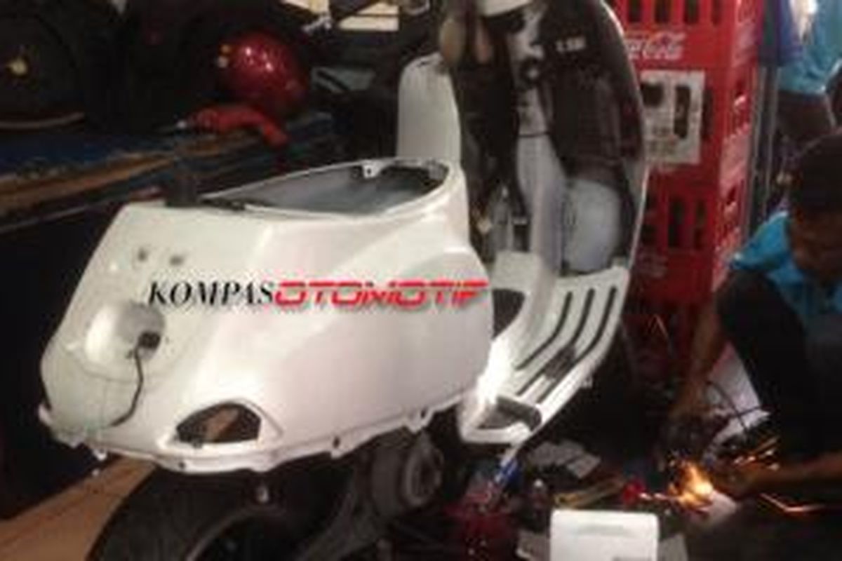 Salah satu mekanik Scooter Layur sedang melakukan perbaikan pada Vespa konsumennya.