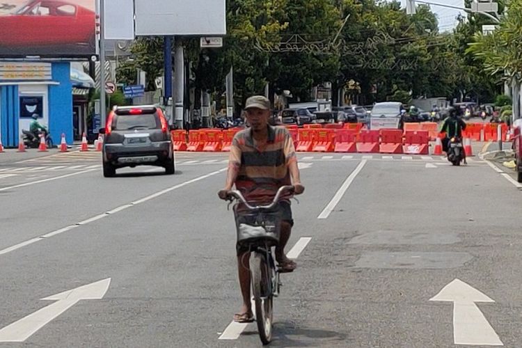 Seorang warga bersepeda melintasi jalan protokol Kota Tegal yang sudah dibatasi dengan ditutup water barrier, Sabtu (28/3/2020)