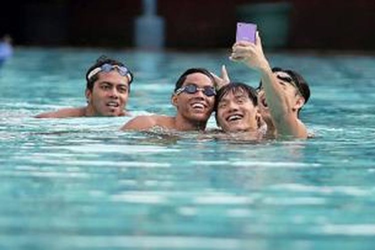 Perenang Indonesia, I Gede Siman Sudartawa (kiri), Alexis Wijaya (dua dari kanan), Dennis Joshua Tiwa (kanan), dan Nadim Zainal (DKI Jakarta) berfoto selfie usai barlatih di Kolam Renang Cikini, Jakarta, sebagai persiapan jelang Asian Games 2014 di Incheon, Korea Selatan.