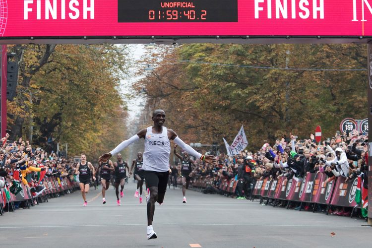 Pelari Kenya Eliud Kipchoge melewati garis finish dalam upaya memecahkan rekor marathon di bawah 2 jam pada 12 Oktober 2019 di Vienna.  Dengan catatan waktu 1jam 59 menit 40.2 detik, juara Olympiade itu menjadi orang pertama yang menyelesaikan marathon di bawah dua jam dengan kondisi yang diatur dan menggunakan sepatu berteknologi dari Nike. (Photo by ALEX HALADA / AFP)