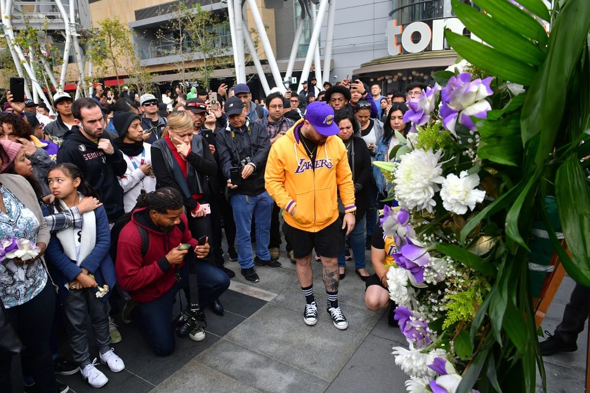 Warga berkumpul di sebuah memorial mantan pemain NBA Kobe Bryant di LA Live plaza di depan Staples Center Los Angeles pada 26 Januari 2020. 