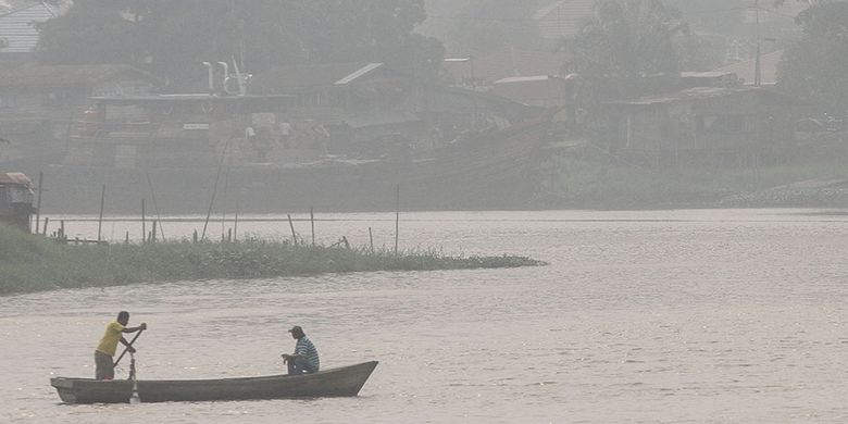 Ojek perahu melintas di sungai Siak yang terpapar kabut asap dampak dari kebakaran lahan, di Pekanbaru, Riau, Sabtu (7/9/2019). Dinas Kesehatan setempat menghimbau kepada seluruh masyarakat agar selalu mengenakan masker pelindung pernapasan di saat beraktivitas di luar ruangan.