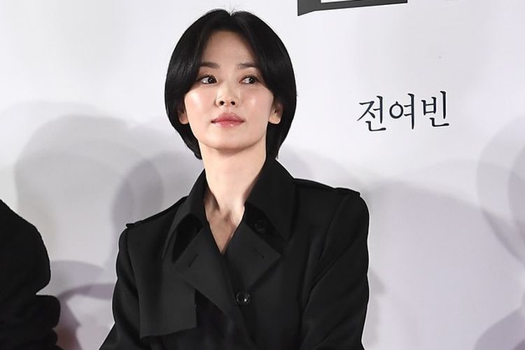 Song Hye Kyo mengenakan celana panjang hitam.