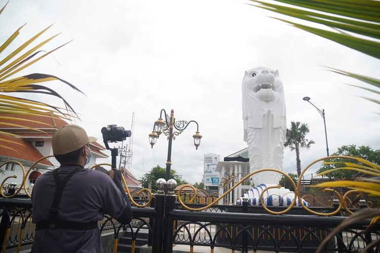 AMBIL FOTO-Warga mengambil foto patung merlion yang dibangun Pemkot Madiun