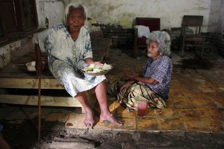 Manis (99) menyuapi Saerah (80) yang lumpuh di Kampung Pecilon Duku, Kecamatan Kedawung, Kabupaten Cirebon Selasa (21/3/2017). Keduanya hidup bertahun-tahun di rumah tua dengan kondisi memprihatinkan, dan menanti belasasihan saudara dan tetangga untuk dapat makan. 