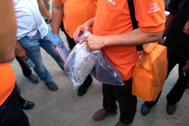 Tim Inafis membawa dua plastik diduga berisi pakaian dari penggeledahan di tiga rumah di Sicanangg, Belawan pada Jumat siang hingga sore. Satu barang lagi dalam plastik transparan dibawa petugas yang lain.