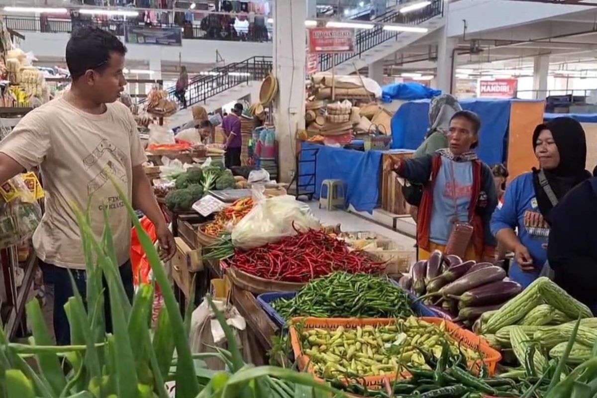 MELONJAK--Menjelang libur panjang, harga sayuran dan sejumlah bahan pokok melonjak naik di pasar tradisional Ngawi, Kabupaten Ngawi, Jawa Timur. Nampak pembeli sementara berbelanja sayuran di Pasar Besar Ngawi. 