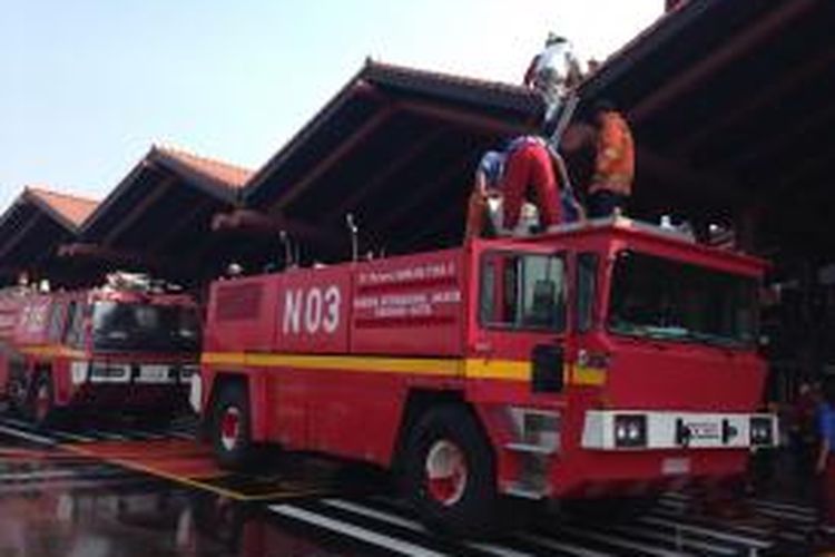 Petugas pemadam kebakaran masih berupaya memadamkan api di Terminal 2E Bandara Soekarno-Hatta, Tangerang, Minggu (5/7/2015) sekitar jam 10.00 WIB. 