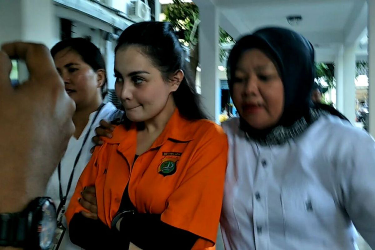 Jennifer Dunn dengan dua tangan diborgol digiring dari Rumah Tahanan Narkoba Polda Metro Jaya ke Dit Res Narkoba Polda Metro Jaya, Jakarta Selatan, Selasa (9/1/2018).