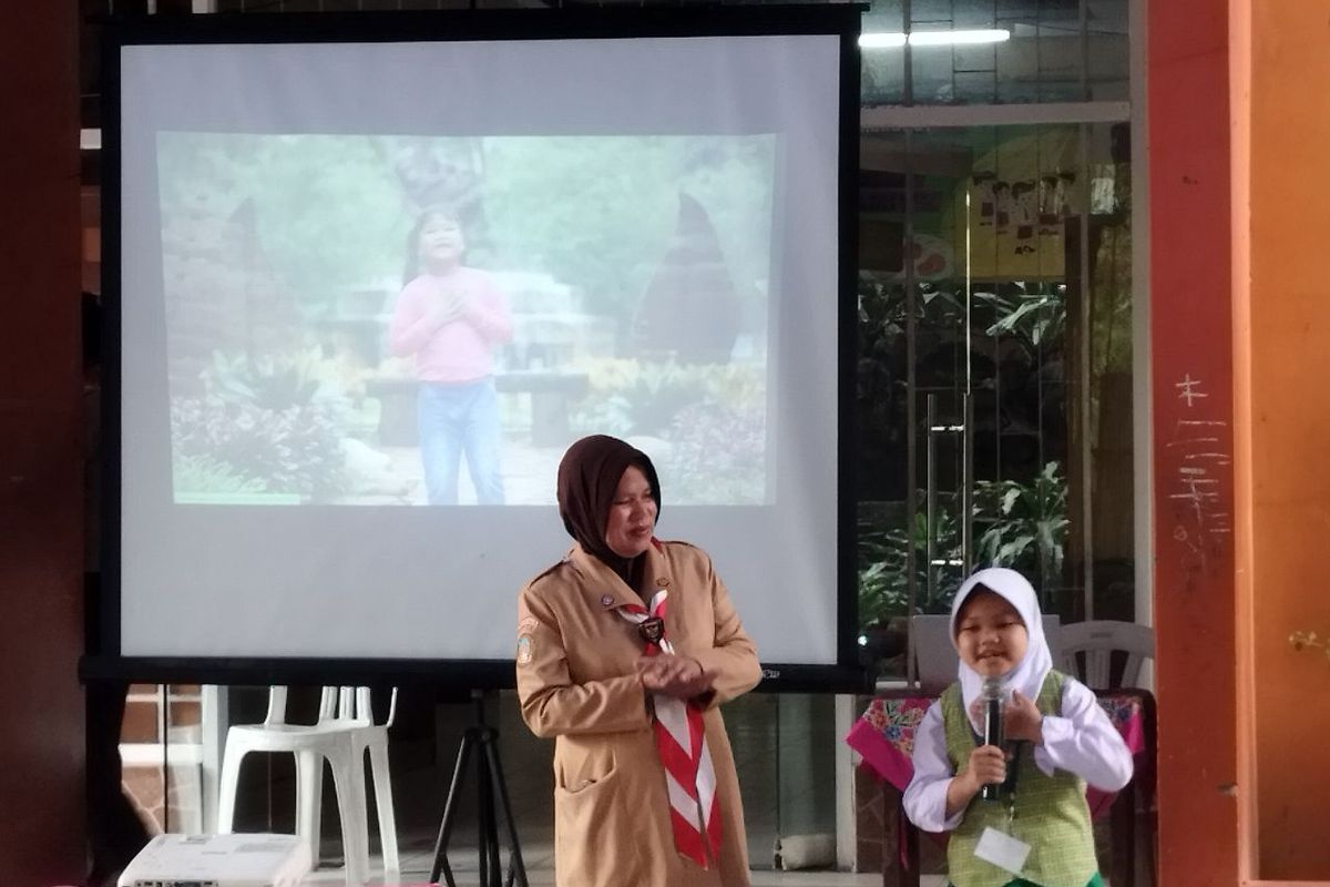 Adelia (6) membawakan lagu Kebun Binatang didampingi Kepala Sekolah Sri Suhartuti di SDN Krukut, Taman Sari, Jakarta Barat, Rabu (11/7/2023). (KOMPAS.com/XENA OLIVIA)
