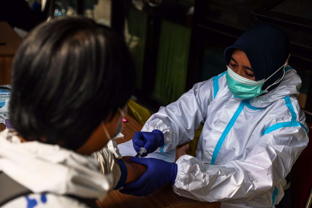 Tenaga kesehatan menggunakan alat pelindung diri (APD) mengambil sampel darah dengan metode rapid test di Stadion Patriot Chandrabhaga, Bekasi, Jawa Barat, Kamis (10/9/2020). Sebanyak 55 tempat tidur telah disiapkan pihak Pemerintah Kota Bekasi di stadion tersebut sebagai tempat untuk isolasi mandiri pasien Covid-19.