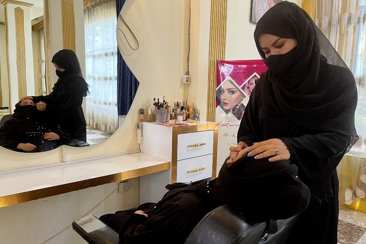 Seorang penata rias perempuan Afghanistan merias wajah pelanggannya di sebuah salon kecantikan di Kabul, Afghanistan, pada 23 Juli 2023. 