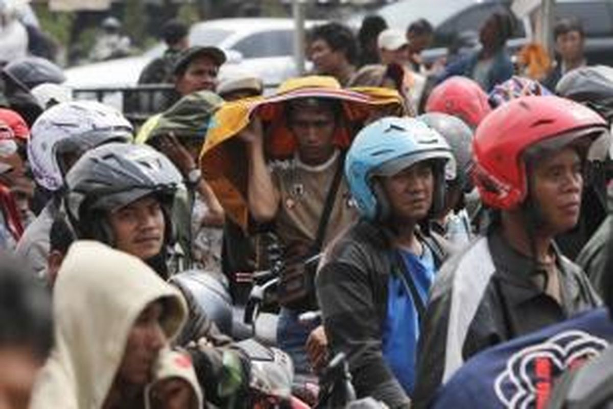 Warga membawa sepeda motor mereka antre mendaftarkan diri sebagai pengemudi ojek GrabBike di Senayan, Jakarta Pusat, Rabu (12/8/2015). Lowongan kerja sebagai pengemudi ojek online tersebut memanfaatkan teknologi digital yang lebih cepat dan transparan.