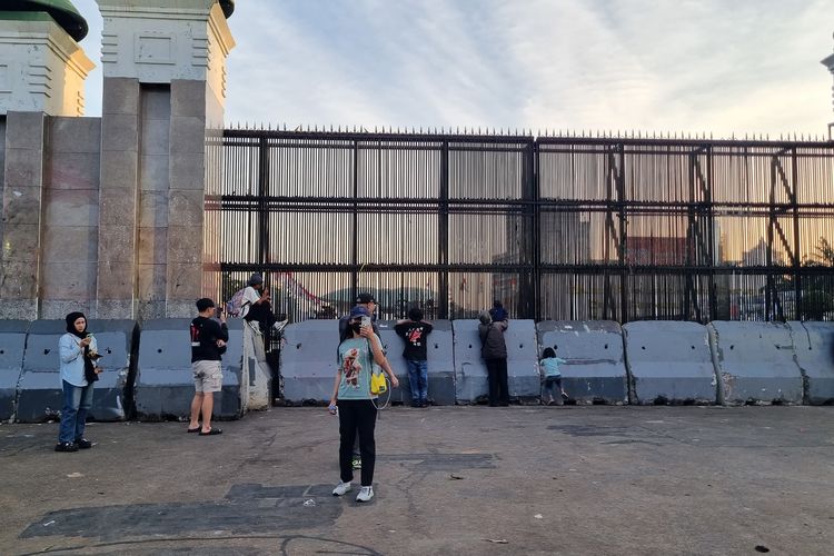 Warga hingga pengemudi ojek online melakukan siaran langsung (live) di media sosial di depan Gedung DPR RI, Senayan, Jakarta Pusat, Selasa (2/9/2025)