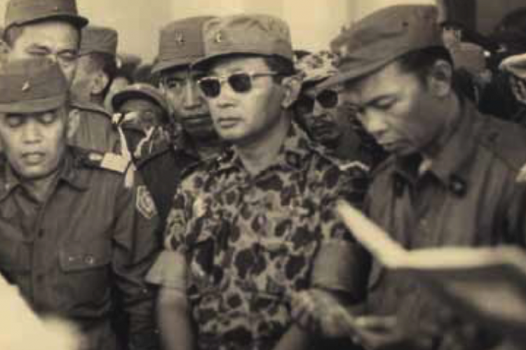 Jenderal Abdul Haris Nasution dan Mayor Jenderal Soeharto berdoa di depan peti
jenazah almarhum Jenderal Sutojo Siswomihardjo dan enam rekannya yang gugur dalam Peristiwa 1 Oktober 1965. Pagi 5 Oktober 1965, hari ulang tahun Angkatan Bersenjata yang biasanya gilang-gemilang, saat itu kelabu, demikian kata-kata pengantar Jenderal Nasution. Tujuh peti jenasah berangkat beriringan dari Markas Besar Angkatan Darat (MBAD). Adegan dalam foto ini muncul dalam film Pengkhianatan G 30 S/PKI dalam bentuk dokumentasi aslinya. (Foto: koleksi pribadi Nani Nurrachman Sutojo, dimuat dalam buku Kenangan tak Terucap, Saya, Ayah dan Tragedi 1965 terbitan Penerbit Buku Kompas, 2013).  