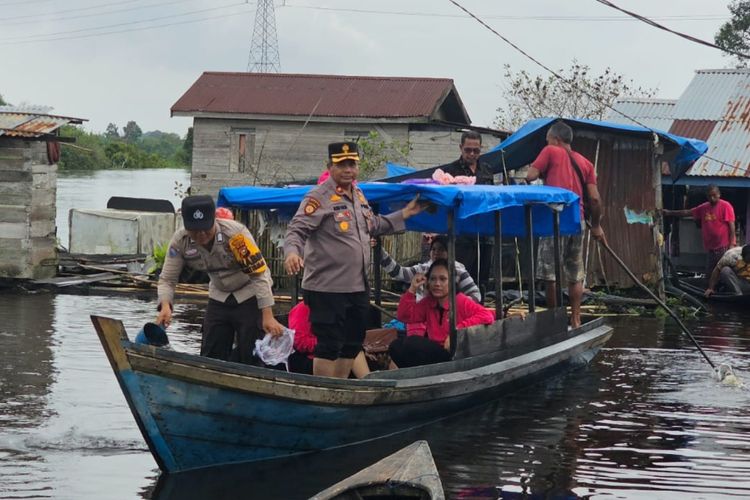 Kapolsek Pangkalan Kuras, Kompol Alwis Saldi dan anggotanya saat menyalurkan bantuan sembako kepada warga terdampak banjir, di Desa Kemang, Kecamatan Pangkalan Kuras, Kabupaten Pelalawan, Riau, Jumat (12/1/2024).