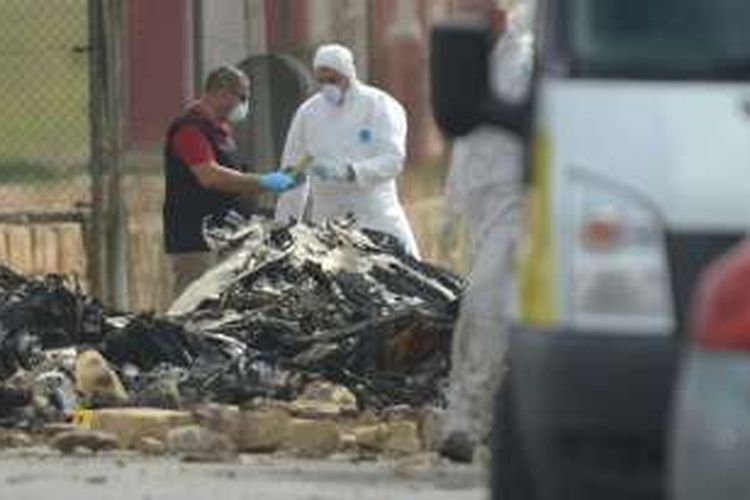 Petugas forensik di Bandara Internasional Malta sedang bekerja menyelidiki sisa-sisa pesawat yang hancur terbakar dalam kecelakaan Senin siang.  