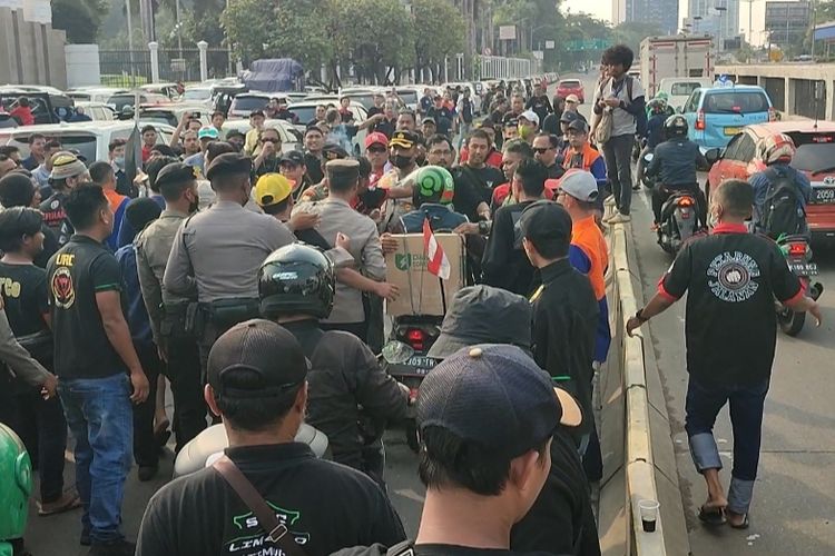 Aksi unjuk rasa yang digelar oleh massa sopir taksi online di depan Gedung DPR/MPR, Senayan, Jakarta, Rabu (21/9/2022) siang, kian memanas.  