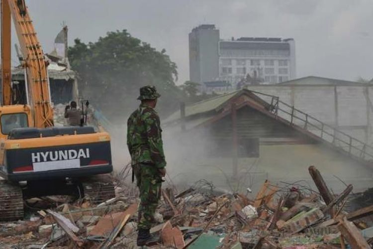 Seorang tentara menyaksikan eksekusi pembongkaran bangunan di Kalijodo, Jakarta, Senin (29/2/2016). Kawasan yang kerap dikenal sebagai tempat hiburan malam itu akan menjadi ruang terbuka hijau.