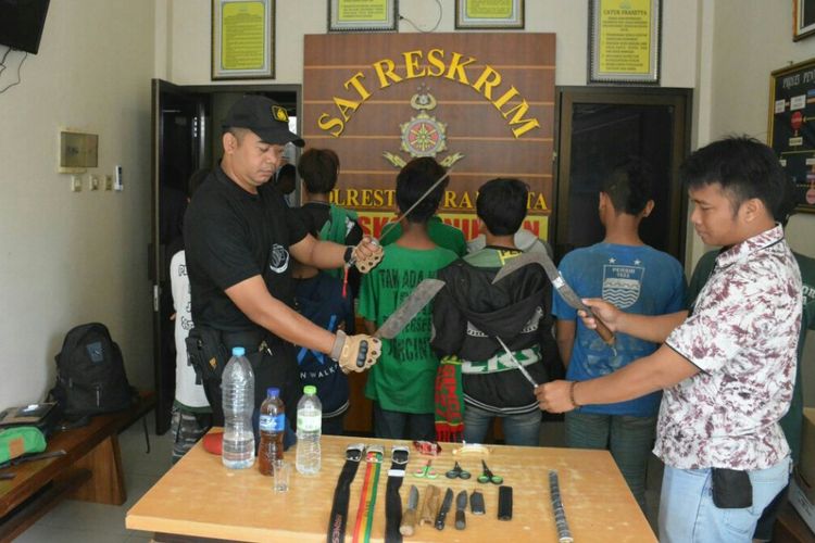 Anggota Polresta Surakarta menunjukkan sajam yang berhasil diamankan dari belasan suporter fanatik Persebaya di kawasan Manahan, Solo, Jawa Tengah, Sabtu (3/2/2018).