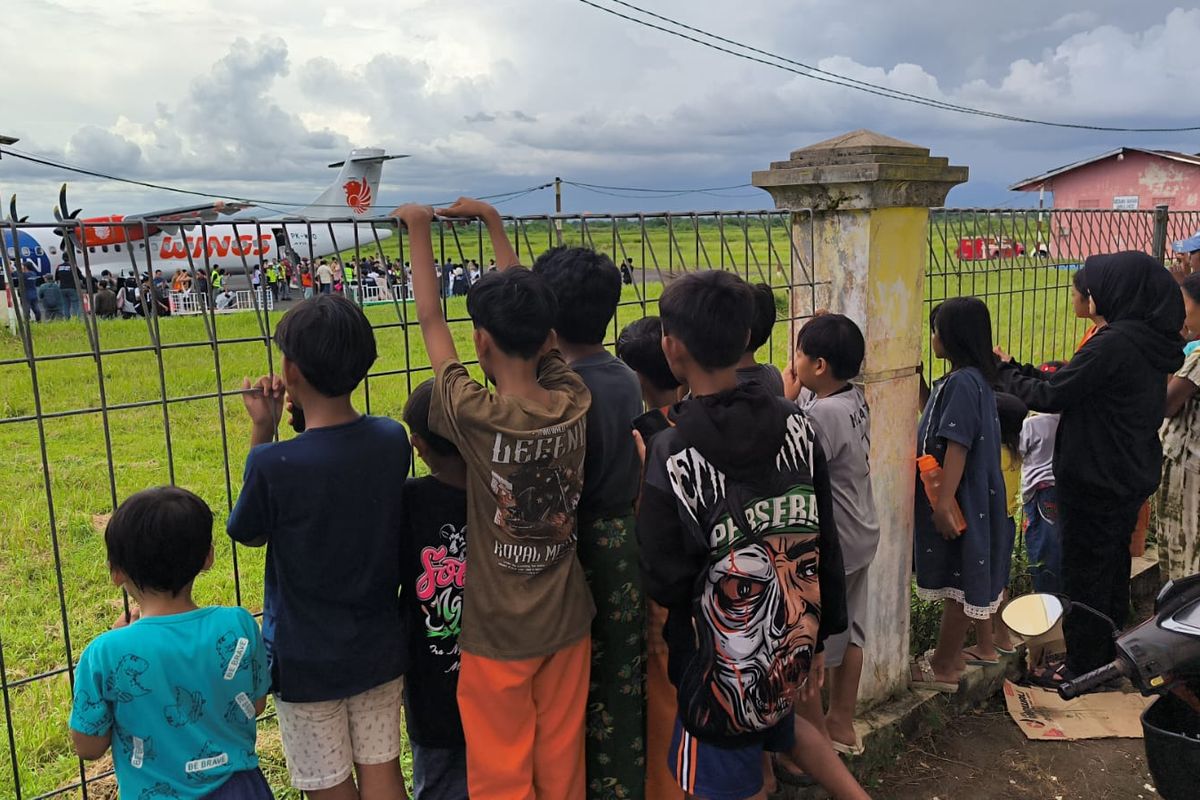 Masyarakat antusias melihat pesawat Wings Air dari balik pagar yang bersiap take off dari Bandara Notohadinegoro Jember menuju Bandara Internasional I Gusti Ngurah Rai, Bali, Jum'at (5/12/2025).