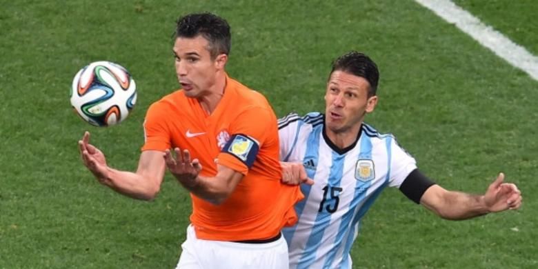 Striker Belanda, Robin van Persie (kiri), dikawal ketat bek Argentina, Ezequiel Lavezzi (kanan), pada laga semifinal Piala Dunia 2014 di Arena Corinthians, Sao Paulo, Rabu (9/7/2014).