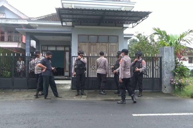 Polisi berjaga di depan rumah pasca penangkapan terduga teroris di Kabupaten Tulungagung Jawa Timur, Selasa (30/03/2021).
