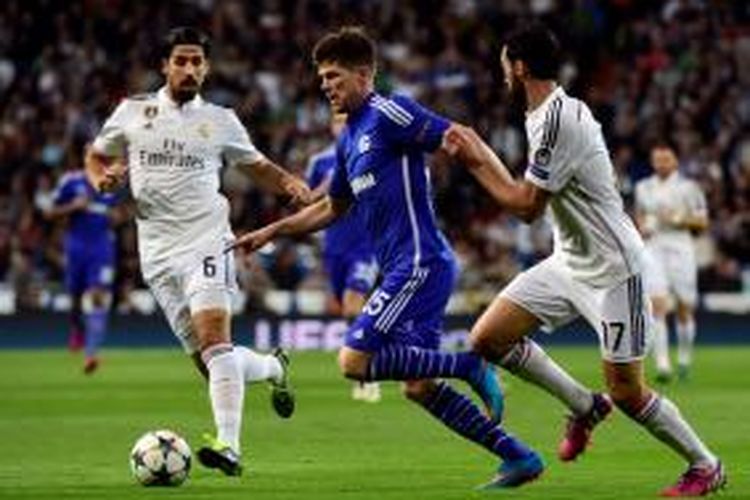 Striker Schalke, Klaas-Jan Huntelaar (tengah) berada dalam kawalan pemain Real Madrid pada leg kedua 16 besar Liga Champions, di Santiago Bernabeu, Rabu (10/3/2015). 