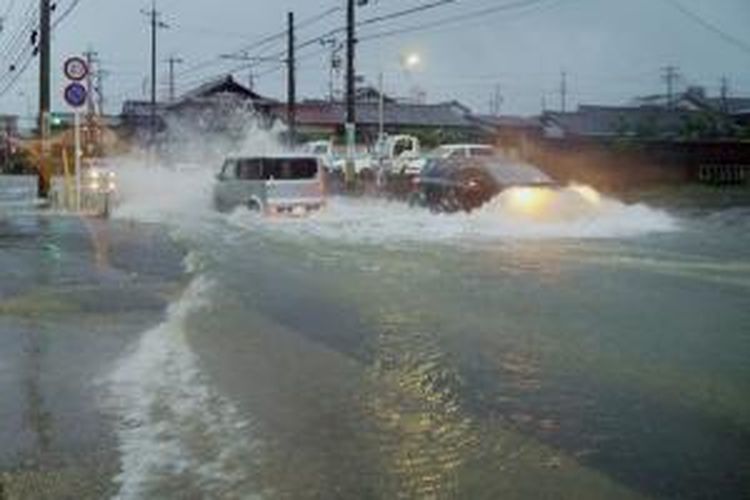 Sejumlah mobil nekat menerobos jalan yang tergenang di kota Tsu, Prefektur Mie akibat Taifun Halong yang membawa hujan lebat di wilayah baratdaya Jepang.