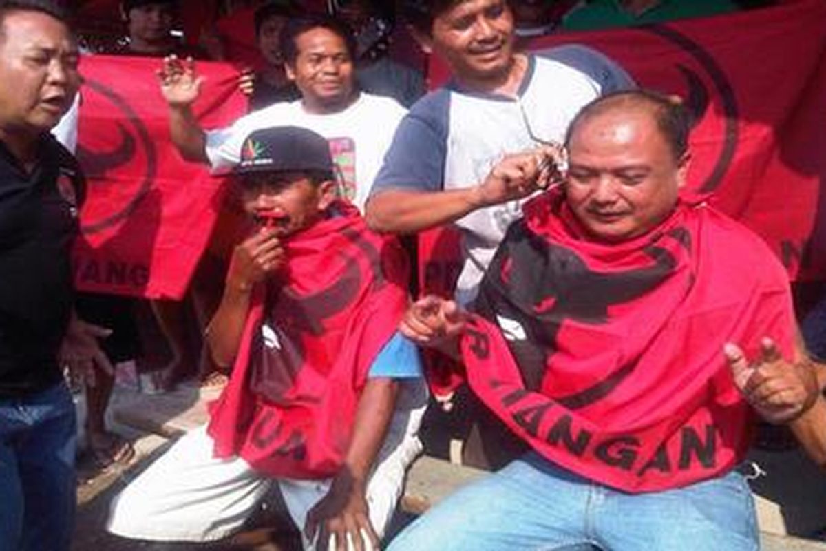 Aksi cukur kumis dan potong rambut kader PDIP Kabupaten Madiun, Jawa Timur, Kamis (20/9/2012).  