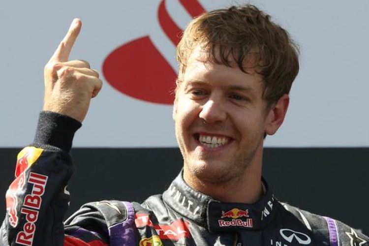 Pebalap Red Bull, Sebastian Vettel, merayakan kemenangannya pada GP Jerman, di atas podium Sirkuit Nurburgring, Minggu (7/7/2013).