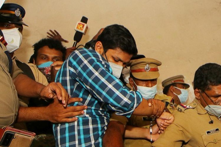 Polisi menahan Sooraj Kumar (baju biru garis kotak) setelah dijatuhi hukuman penjara seumur hidup karena membunuh istrinya dengan ular berbisa, di Kollam di negara bagian Kerala, India, pada 13 Oktober 2021.