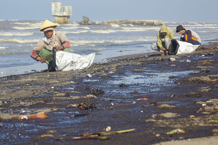 Warga mengumpulkan tumpahan minyak (Oil Spill) yang tercecer di Pesisir Pantai Cemarajaya, Karawang, Jawa Barat, Senin (22/7/2019). Tumpahan minyak tersebut tercecer di sepanjang pantai Sedari hingga pantai Cemarajaya akibat kebocoran pipa proyek eksplorasi minyak milik Pertamina.