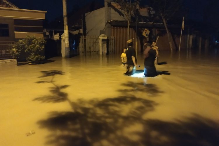 Warga Kelurahan Jungcangcang melintas di jalan R. And Aziz yang digenangi ai, Ahad (14/4/2019). 