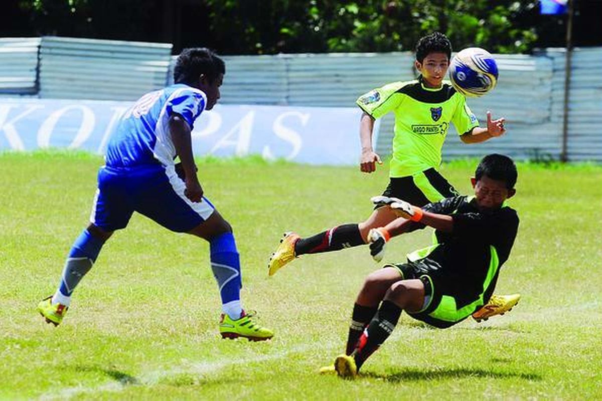 Kiper SSB Tangerang Raya, Damas Nugraha (kanan), berhasil menghalau tendangan pemain SSB Mitra Pespex United, Azura Ramadhan Aji (kiri), dalam lanjutan Liga Kompas Gramedia U-14 di Stadion Ciracas, Jakarta Timur, Minggu (25/3). Mitra Pespex United menang telak, 13-0. 