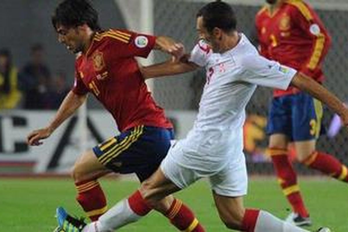 Pemain Georgia, David Kvirkvelia (kanan), mengawal ketat gelandang Spanyol, David Jimenes Silva (kiri), dalam lanjutan Kualikasi Piala Dunia Brasil 2014 di Tbilisi pada 11 September 2012. 