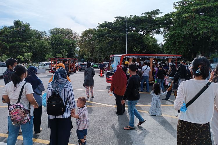 Pengunjung menghampiri odong-odong gratis yang disediakan pengelola TMII karena takut tidak kebagian tempat duduk. Pemandangan itu terlihat saat TMII dibuka kembali pada hari ini, Minggu (20/11/2022). 