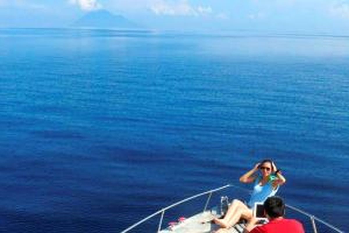 Bunaken, Sulawesi Utara, menjadi salah satu daya tarik bagi wisatawan  untuk datang ke  Manado. Di kapal yang membawa ke lokasi selam dan snorkeling, penumpang  berfoto dengan latar belakang Gunung Manado Tua dan Pulau Bunaken.