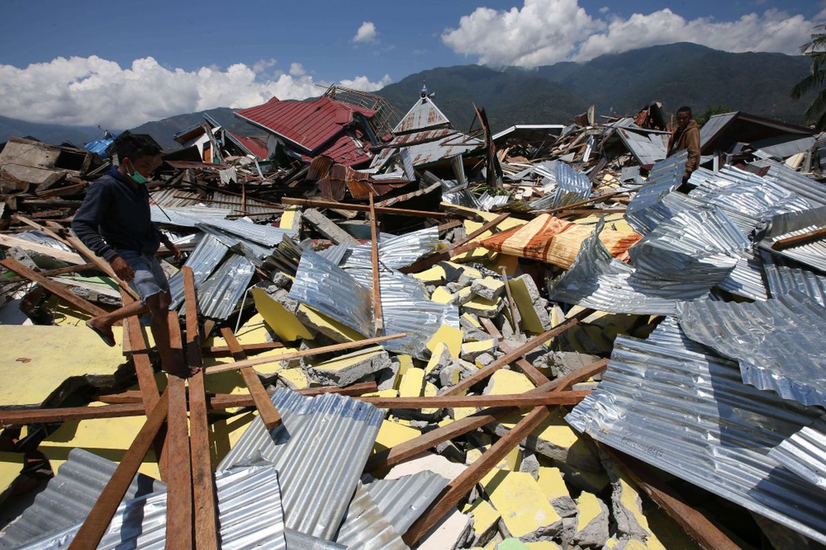 Puing bangunan di Perumnas Balaroa akibat gempa bumi yang mengguncang Kota Palu, Sulawesi Tengah, Minggu (30/9/2018). Gempa bermagnitudo 7,4 mengakibatkan ribuan bangunan rusak dan sedikitnya 420 orang meninggal dunia.