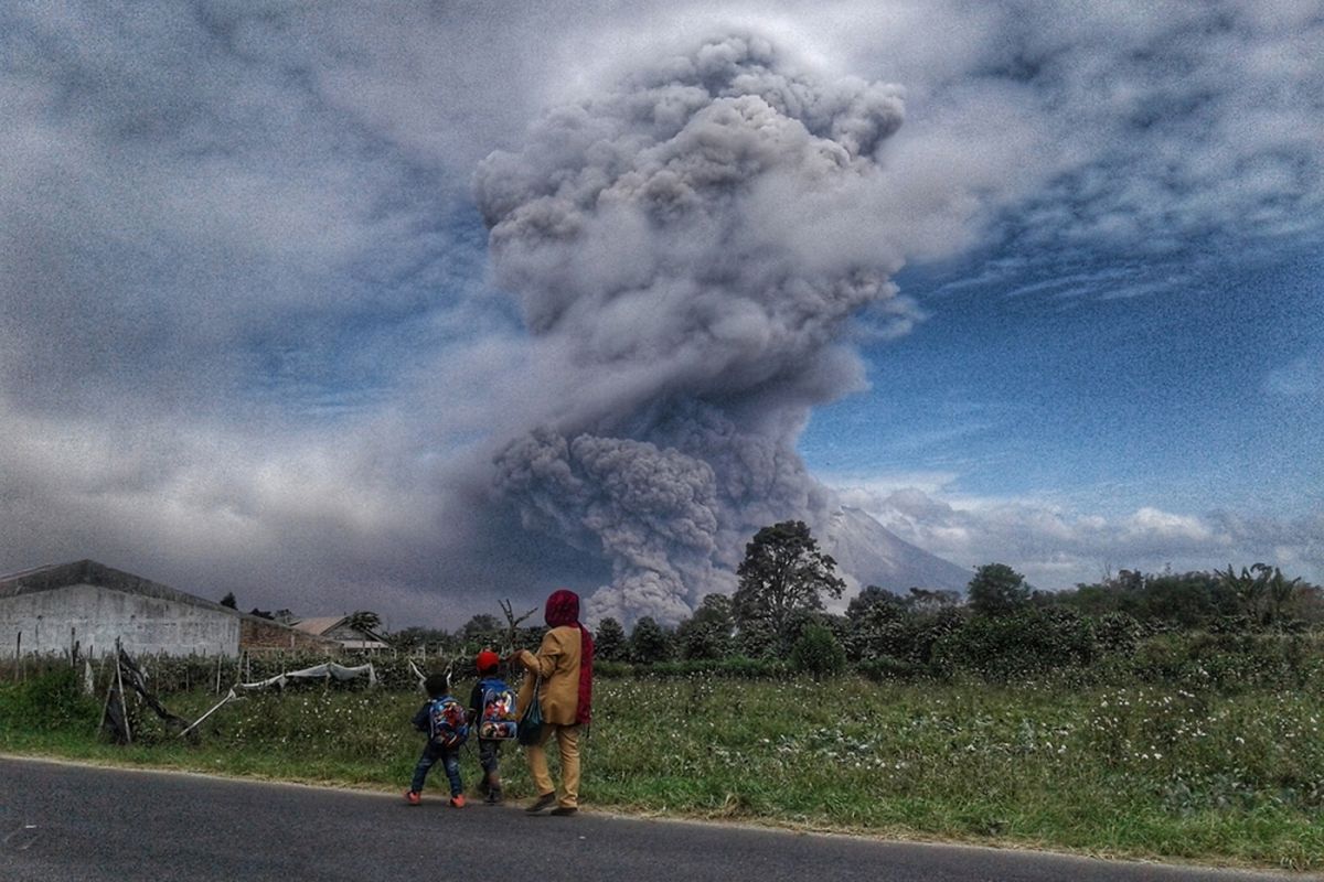 Warga melihat Gunung Sinabung menyemburkan material vulkanik saat erupsi, di Karo, Sumatera Utara, Rabu (2/8/2017). Aktivitas Sinabung kembali meningkat sejak Rabu pagi, tercatat puluhan kali gunung itu melontarkan abu dan awan panas yang menyebabkan aktivitas warga terganggu.