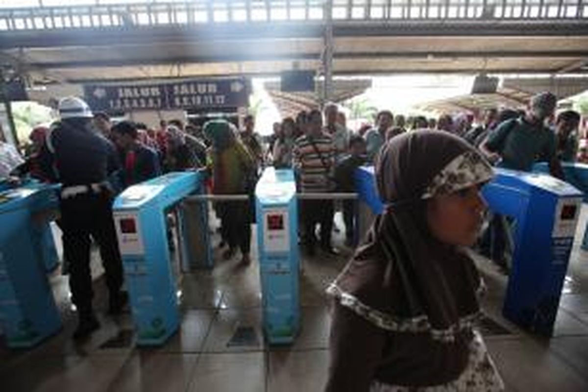 Antrean penumpang commuter line melintasi gerbang otomatis setibanya di Stasiun Kota, Jakarta Barat, Senin (16/6/2014). PT. KAI Commuter Jabodetabek (KCJ) bekerja sama dengan Bank BRI, Bank Mandiri, dan Bank BNI meresmikan penggunaan kartu prabayar sebagai e-ticketing untuk pembayaran tiket kereta commuter line.
