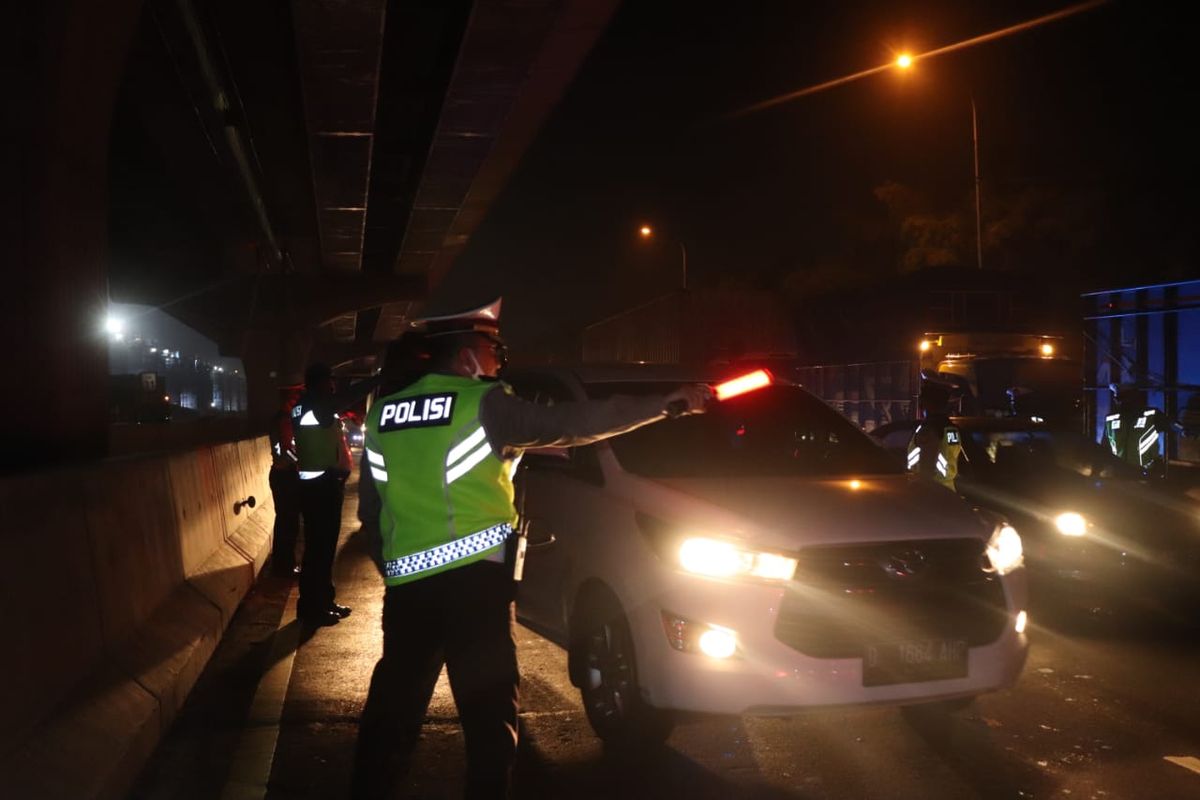 Kepolisian mulai mengatur kendaraan lalu lintas yang melewati Jalan Tol Jakarta-Cikampek yang kini mulai disekat sejak penerapan larangan mudik, Jakarta, Jumat (24/4/2020).