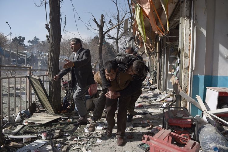 Warga membawa korban luka dalam insiden bom bunuh diri menggunakan ambulans di pusat kota Kabul, Afghanistan, Sabtu (27/1/2018).