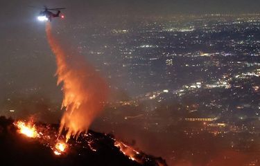 Helikopter menyemprotkan air untuk memadamkan kebakaran hutan Los Angeles atau Sunset Fire di Hollywood Hills, Negara Bagian California, Amerika Serikat, Rabu (8/1/2025).