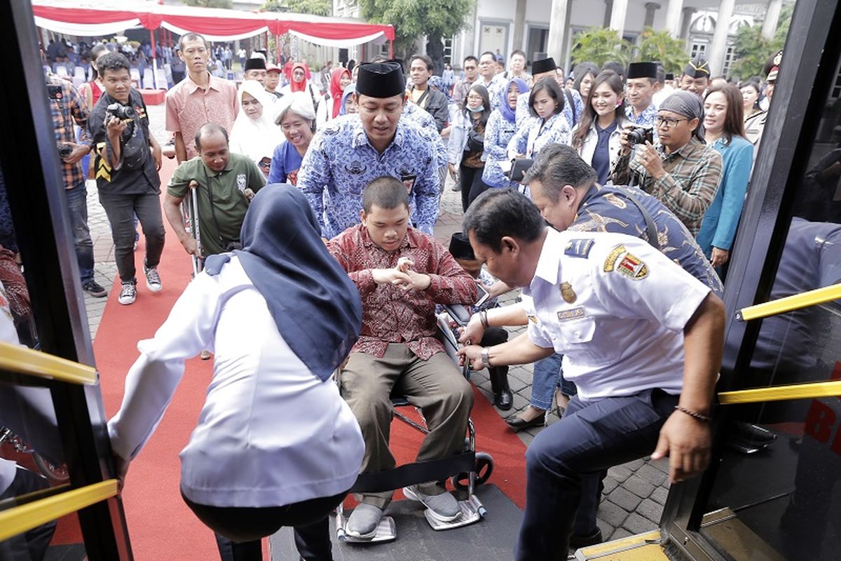 Wali Kota Semarang Hendrar Prihadi mendorong kursi roda penyandang difabel menuju bus tingkat wisata Si Kuncung pada peringatan 3 tahun kepemimpinannya di halaman Balai Kota Semarang, Senin (18/2/2019).